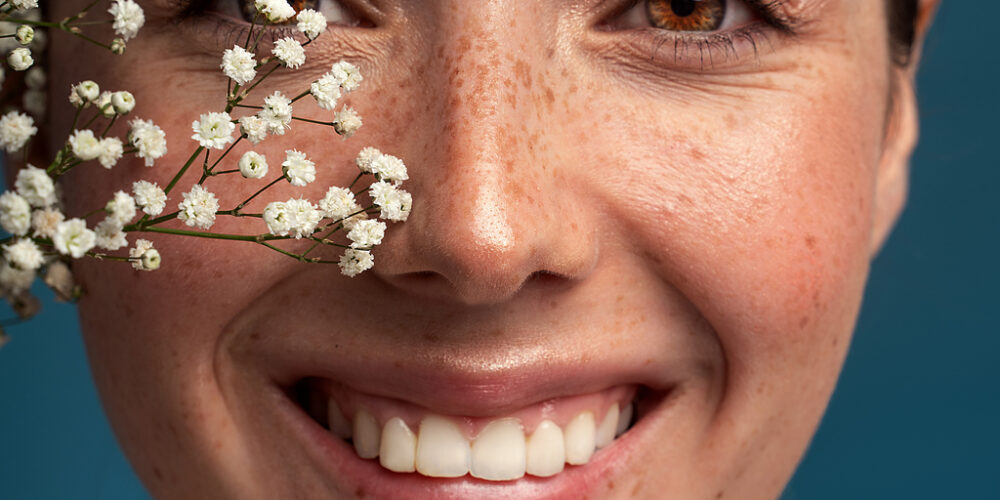 A Woman Smiles After Receiving Cosmetic Dermatology Treatments Like Botox And Microneedling, Showcasing Her Revitalized And Glowing Skin At The Start Of Spring.
